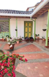 uma casa com uma porta verde e algumas flores em Villa Linda 2 em Jericó