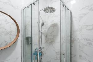 a shower with a glass door and a mirror at Cosy House in Porto Marina in Vila Nova de Gaia