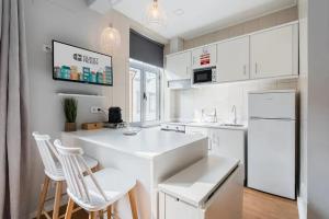 a kitchen with white appliances and white cabinets at Cosy House in Porto Marina in Vila Nova de Gaia