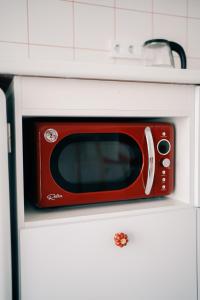 a red microwave sitting on top of a white cabinet at Идеальный домик для отдыха in Almaty