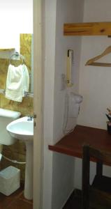 a bathroom with a sink and a phone on the wall at Hostería Montes in San Ignacio