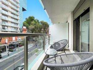 d'un balcon avec deux chaises et une vue sur la rue. dans l'établissement Exclusivo apartamento en Punta Carretas, à Montevideo