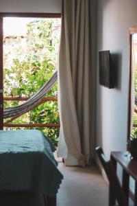 伊卡萊的住宿－Pousada Casa de Hóspedes，一间卧室设有一张床和一个滑动玻璃门