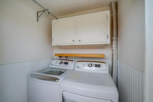 lavadora y secadora en una pequeña lavandería en Chic Bakersfield Apartment about 5 Mi to Downtown!, en Bakersfield
