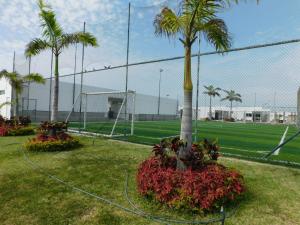 a soccer field with palm trees and a fence at Casa Florencia gran piscina in Salinas