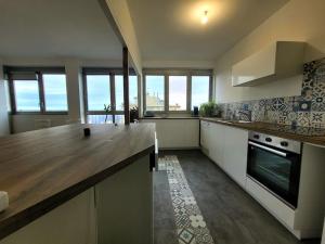 a kitchen with a counter top and some windows at La Case à Jeannette in Châteauroux