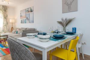 a dining room with a white table and yellow chairs at Cozy beachfront 2BR with Terrace, Pool and Garage in Sitio de Calahonda +38 photos