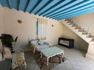 a living room with a blue ceiling and stairs at Dar El Jerbiya in Midoun