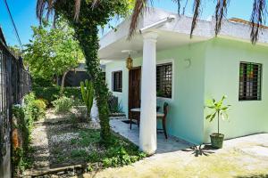 een wit huis met een palmboom in de tuin bij Lily House 3 in San Felipe de Puerto Plata