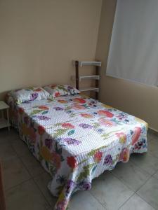 a bed with a quilt on it in a room at Ciudad Cultural in San Salvador de Jujuy