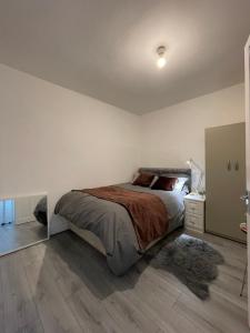 a bedroom with a large bed and a wooden floor at COZY ROOMS 25 min LIVERPOOL STREET in London