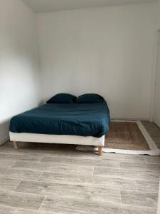 a bedroom with a bed with a blue comforter at Maison plain pied au calme proche centre d’Orléans in Orléans