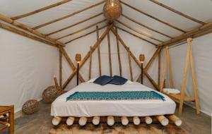 - une chambre avec un lit dans une tente dans l'établissement Glamping Las Olas by Rotamundos, à Montepio