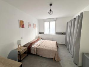 1 dormitorio con cama, mesa y ventana en 178B - Appartement T2 Tout Confort - Wifi Netflix, en Le Gond-Pontouvre