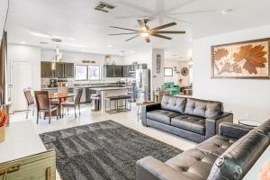 a living room with a couch and a kitchen at Sunny Peoria Home with Private Pool and Gas Grill! in Peoria