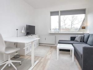 un soggiorno bianco con divano e scrivania di Holiday home Grenaa XXXVIII a Grenå