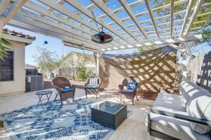 a patio with chairs and a pergola at Sunny Peoria Home with Private Pool and Gas Grill! in Peoria