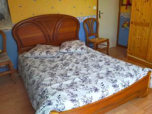 een slaapkamer met een groot bed met een houten frame bij Entre Bretagne ET Normandie in Avranches