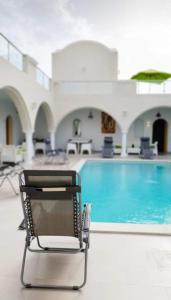 a chair sitting in front of a swimming pool at Musk de djerba suite aziz avec piscine in Temlale