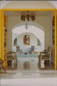 a living room with a pool and chairs and a chandelier at Musk de djerba suite aziz avec piscine in Temlale