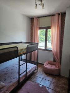 Cette chambre dispose de lits superposés et d'une fenêtre. dans l'établissement La Casona de Simón, un pequeño paraíso urbano, à Camarma de Esteruelas