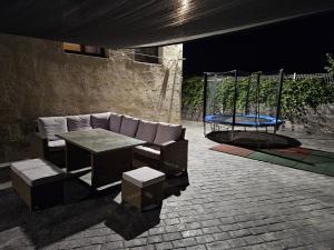 - un canapé et une table sur une terrasse la nuit dans l'établissement La Casona de Simón, un pequeño paraíso urbano, à Camarma de Esteruelas