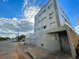 um grande edifício branco com uma porta num parque de estacionamento em 104 - Apartamento Completo para até 7 Hóspedes em Patos de Minas