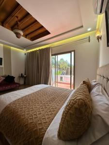 a bedroom with a large bed with a large window at Maison d'hôtes La Ferme AZIZA in Fès