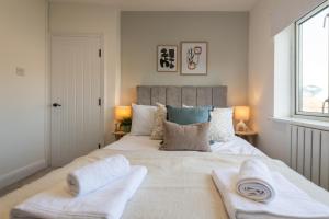 a bedroom with a large bed with two towels on it at Elland Retreat By NordStay in Beeston Hill