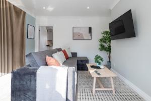 a living room with a couch and a table at Elland Retreat By NordStay in Beeston Hill