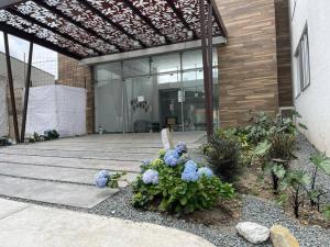 a patio with blue flowers in front of a building at Apartamento frente a Mallplaza in Manizales