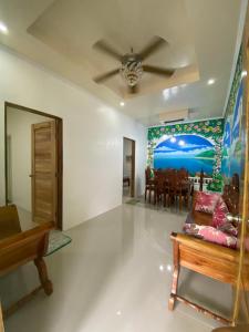 a living room with a ceiling fan and a dining room at Palm Garden Resort in Carles