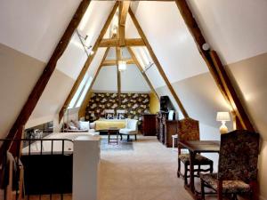 a living room with aamed ceilings and a table and chairs at Manoir de Barbotin in Ploërmel