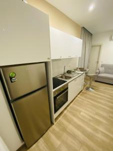 una cucina con frigorifero, lavandino e divano di Block66 a Città di Rodi