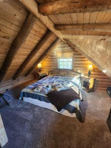 a bedroom with a large bed in a attic at VERY private, real log cabin with hot tub! in Sevierville