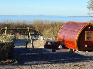 eine Holzhütte mit einem Boot neben einem Tisch in der Unterkunft The Pod Fabulous glamping pod near Snowdonia. in Caernarfon