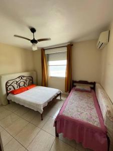 um quarto com 2 camas e uma janela em Apartamento com pé na areia em São Vicente