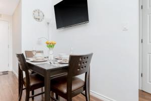 a dining room table with chairs and a tv at Kensington Market Apartment in Toronto