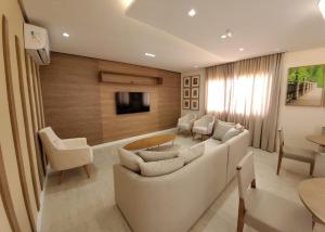 sala de estar con sofá blanco y TV en VIP Stúdio, en Salvador