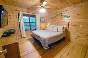 a bedroom with a bed in a log cabin at Wolf`s Den | Blue Ridge GA in Blue Ridge
