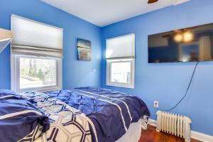 1 dormitorio azul con 1 cama y 2 ventanas en Greenwood Lake Cottage with Shared Dock and Hot Tub!, en Hewitt