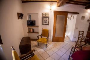 een woonkamer met stoelen en een televisie en een deur bij Casa degli Archi Bibbona alta in Bibbona