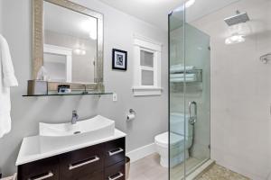 a bathroom with a sink and a glass shower at East Village Apartments in Long Beach +19 photos