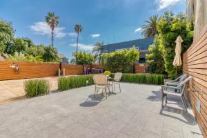 a patio with chairs and a table and an umbrella at East Village Apartments in Long Beach