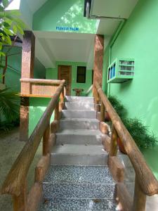 una escalera que conduce a una habitación con paredes verdes en Palm Garden Resort, en Carles