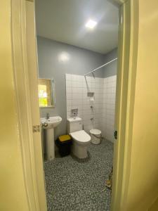 łazienka z toaletą i umywalką w obiekcie Palm Garden Resort w mieście Carles