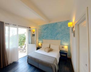 a bedroom with a white bed and a blue wall at Hotel La Villa Del Mare in Cagliari