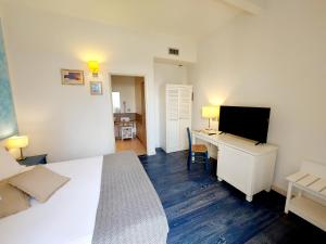 a bedroom with a bed and a desk with a television at Hotel La Villa Del Mare in Cagliari