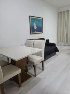 a dining room with a white table and chairs at Flat recém-reformado e bem localizado in Vitória