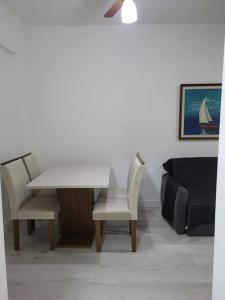ein Esszimmer mit einem weißen Tisch und Stühlen in der Unterkunft Flat recém-reformado e bem localizado in Vitória